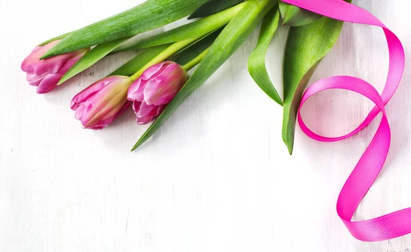 Jarní tulipány na bílém dřevěném pozadí, pohled shora — Stock fotografie