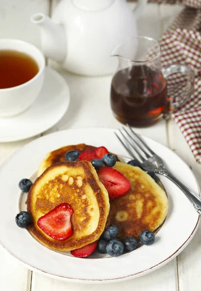 Pancakes with strawberries, blueberries and maple syrup for a br — Stock Photo, Image