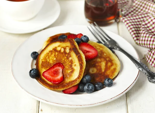 Pancakes with strawberries, blueberries and maple syrup for a br — Stock Photo, Image