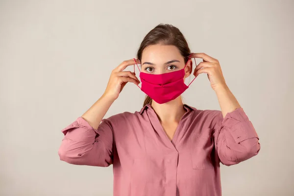 Молодая девушка надевает защитную маску во время пандемии Ковида-19 . — стоковое фото
