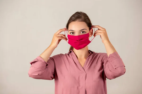 Young girl putting on a protective face mask during a Covid-19 pandemic. — Stock Photo, Image