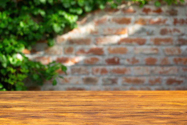 Brick wall background with wood table in front.