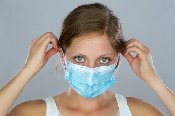 Young woman putting on face mask during pandemic. — Stock Photo, Image