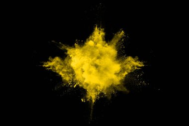 Freeze motion of yellow dust explosion isolated on black background. clipart