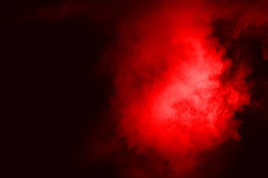 Siyah arka planda soyut kırmızı toz patlaması. Siyah arka planda soyut kırmızı toz sıçramış. Patlayan kırmızı barutun hareketsiz hareketi.