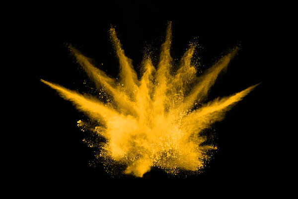 Freeze motion of yellow dust explosion isolated on black background.