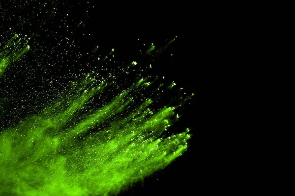 The movement of abstract dust explosion frozen green on black background. Stop the movement of powdered green on black background. Explosive powder green on black background.