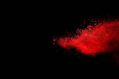 Siyah arka planda soyut kırmızı toz patlaması. Siyah arka planda soyut kırmızı toz sıçramış. Patlayan kırmızı barutun hareketsiz hareketi.