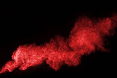 Siyah arka planda soyut kırmızı toz patlaması. Siyah arka planda soyut kırmızı toz sıçramış. Patlayan kırmızı barutun hareketsiz hareketi.