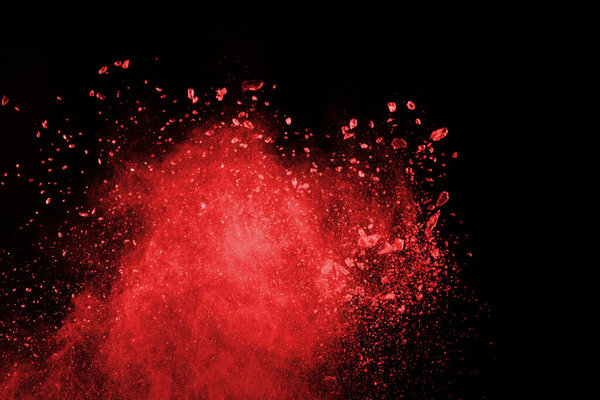 Взрыв красного порошка на черном фоне. Замораживание движения взрывающегося красного порошка.