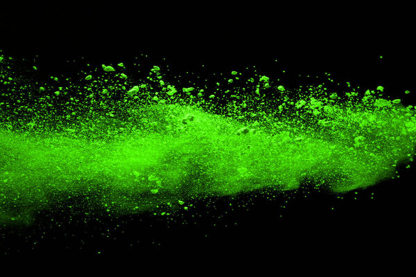 The movement of abstract dust explosion frozen green on black background. Stop the movement of powdered green on black background. Explosive powder green on black background.