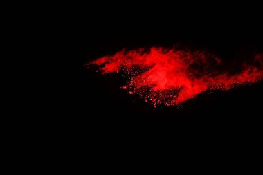 Siyah arka planda soyut kırmızı toz patlaması. Siyah arka planda soyut kırmızı toz sıçramış. Patlayan kırmızı barutun hareketsiz hareketi.