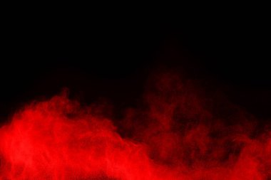 Siyah arka planda soyut kırmızı toz patlaması. Siyah arka planda soyut kırmızı toz sıçramış. Patlayan kırmızı barutun hareketsiz hareketi.