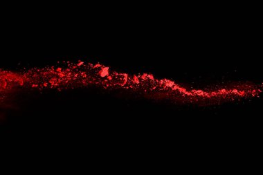 Siyah arka planda soyut kırmızı toz patlaması. Siyah arka planda soyut kırmızı toz sıçramış. Patlayan kırmızı barutun hareketsiz hareketi.
