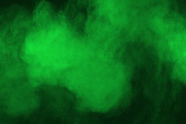 Soyut toz patlamasının hareketi siyah arka planda donmuş yeşil. Siyah zemin üzerindeki toz yeşilinin hareketini durdur. Patlayıcı tozu siyah arkaplanda yeşil.