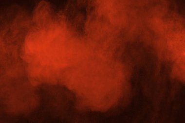 Siyah arka planda soyut kırmızı toz patlaması. Siyah arka planda soyut kırmızı toz sıçramış. Patlayan kırmızı barutun hareketsiz hareketi.