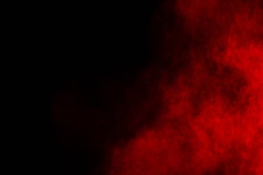 Siyah arka planda soyut kırmızı toz patlaması. Siyah arka planda soyut kırmızı toz sıçramış. Patlayan kırmızı barutun hareketsiz hareketi.