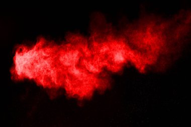 Siyah arka planda soyut kırmızı toz patlaması. Siyah arka planda soyut kırmızı toz sıçramış. Patlayan kırmızı barutun hareketsiz hareketi.