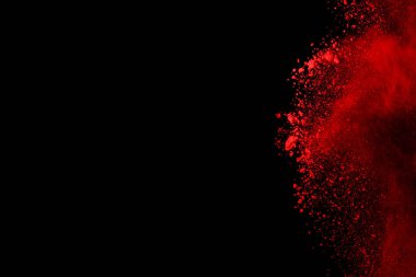 Siyah arka planda soyut kırmızı toz patlaması. Siyah arka planda soyut kırmızı toz sıçramış. Patlayan kırmızı barutun hareketsiz hareketi.