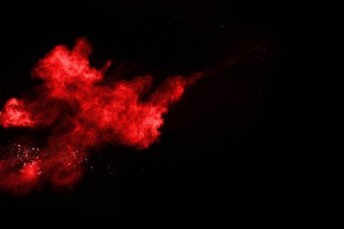 Siyah arka planda soyut kırmızı toz patlaması. Siyah arka planda soyut kırmızı toz sıçramış. Patlayan kırmızı barutun hareketsiz hareketi.