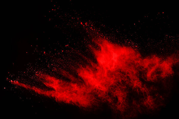 Abstract red powder explosion on black background.abstract red powder splatted on black background. Freeze motion of red powder exploding.