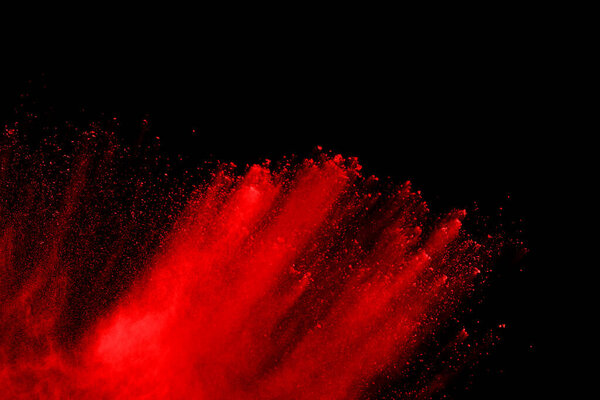 abstract red powder explosion on black background.abstract red powder splatted on black background. Freeze motion of red powder exploding.