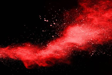 Siyah arka planda soyut kırmızı toz patlaması. Siyah arka planda soyut kırmızı toz sıçramış. Patlayan kırmızı barutun hareketsiz hareketi.