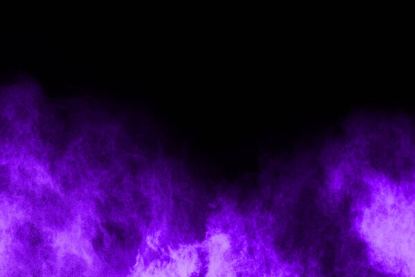 Purple powder explosion on black background. Colored cloud. Colorful dust explode. Paint Holi.