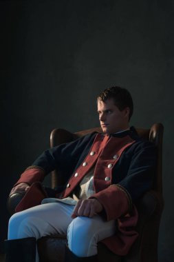 Sandalye bir kenara seyir içinde oturan tarihsel regency adam.