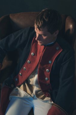 Sandalyede oturan tarihsel regency adam. Yüksek açılı görünüş.