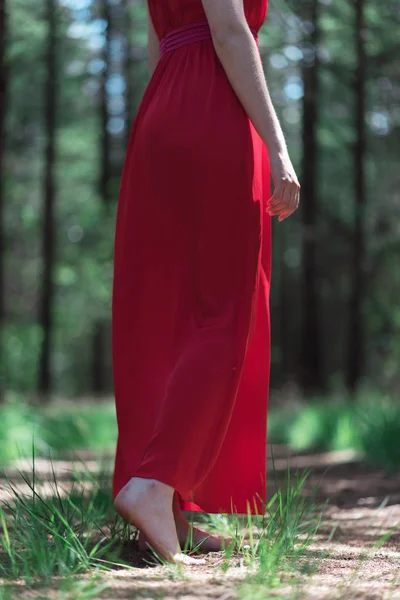 女子穿红裙裸脚在森林小路上 — 图库照片