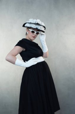 Beyaz güneş gözlüğü ve siyah elbise ciddi retro 1950'lerde hamile kadın.