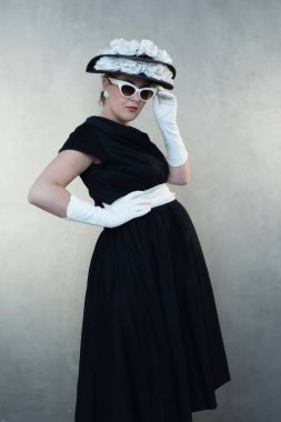 Beyaz güneş gözlüğü ve siyah elbise ciddi retro 1950'lerde hamile kadın.