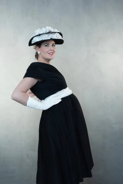 黒のドレスと帽子でレトロな 1950 年代の妊娠中の女性の笑顔 — ストック写真