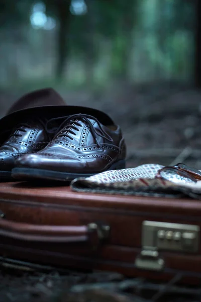 在森林里用鞋子 眼镜和披肩丢弃的公文包 — 图库照片
