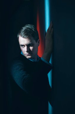 Siyah kazaklı şüpheli adam duvara kırmızı ve b sahanın