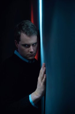 Siyah kazaklı şüpheli adam duvara kırmızı ve b sahanın