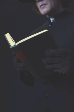 Siyah ceket okuma kitabında gizemli Victorian rahip.