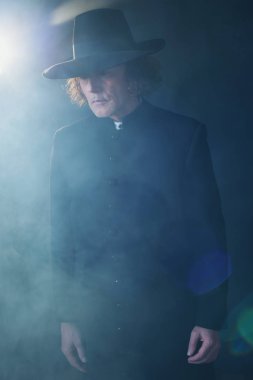 Siyah ceket ve sis şapkalı gizemli Victorian rahip.