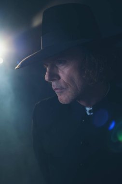 Siyah ceket ve sis şapkalı gizemli Victorian rahip.