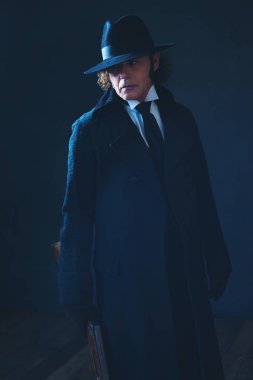 Uzun siyah ceket ve şapka tutan tüfek Victorian adam.