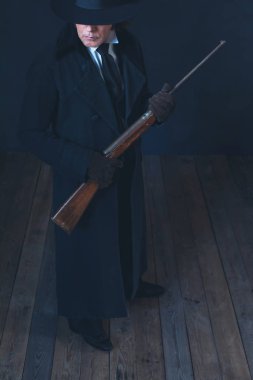 Uzun siyah ceket ve şapka tutan tüfek Victorian adam.