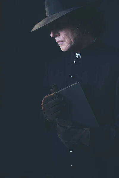 Misterioso sacerdote victoriano en sombrero sosteniendo libro . — Foto de Stock