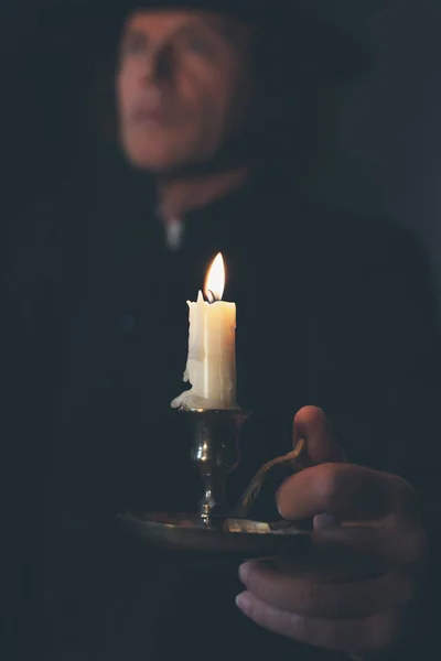 Mystérieux prêtre victorien en manteau noir et chapeau tenant une bougie — Photo