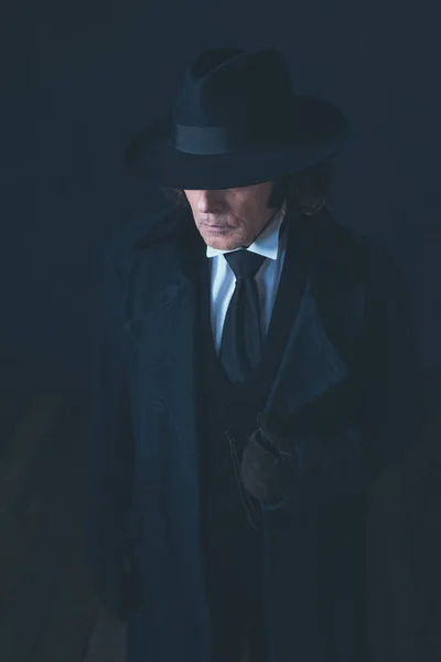 Mysteriöser siegreicher Mann in schwarzem Mantel und Hut. — Stockfoto