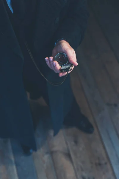 Edwardian homem em casaco preto longo segurando relógio de bolso . — Fotografia de Stock