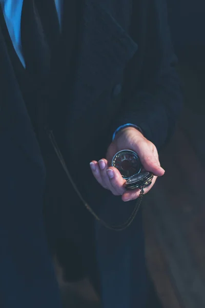 Edwardian man in long black coat holding pocket watch. — Stock Photo, Image