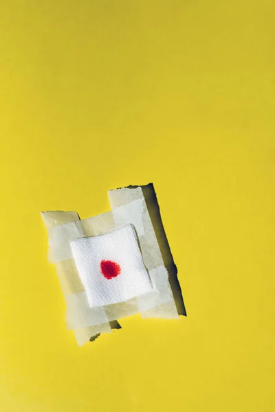 Bandage gauze with blood on yellow background. Top view. — Stock Photo, Image