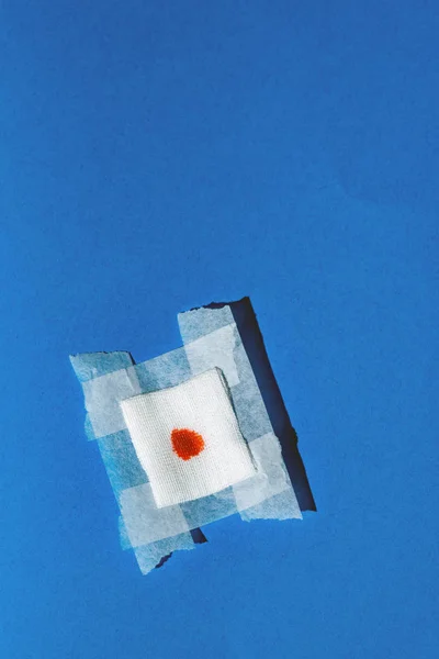 Bandage gauze with blood on blue background. Top view. — Stock Photo, Image