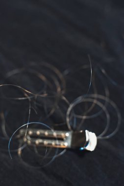 Siyah kumaş üzerinde yatan gevşek saç ile Saç klipsi.